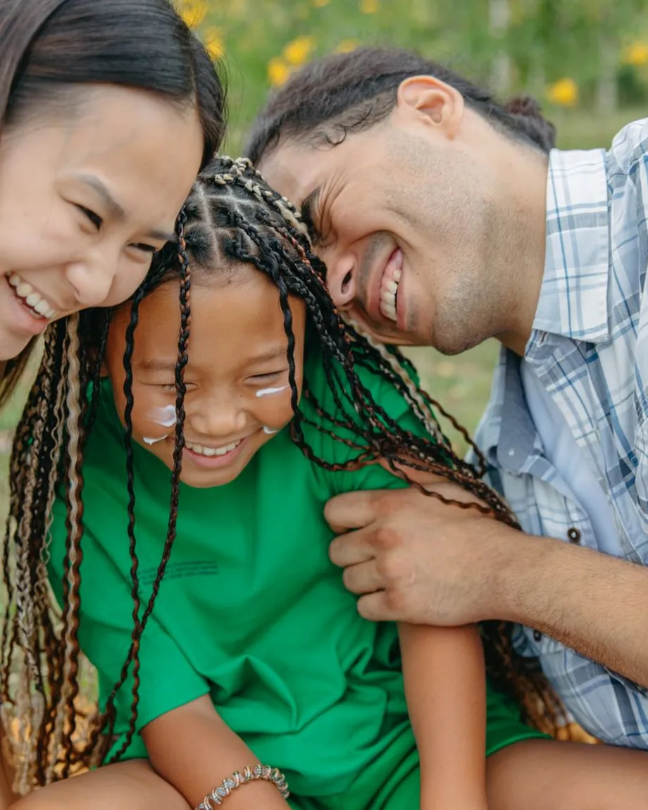 A family laughing with their heads together