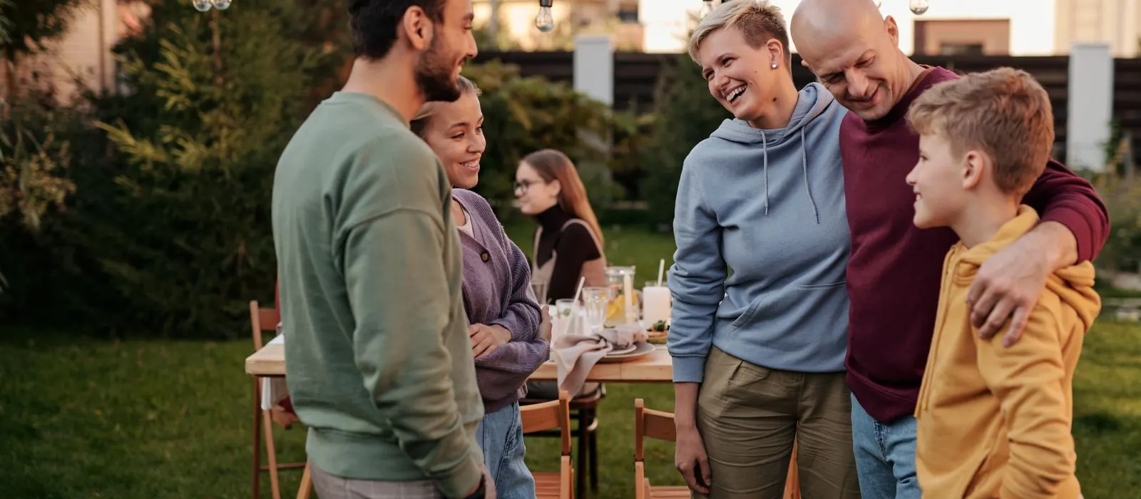 Friends greeting each other at a garden table